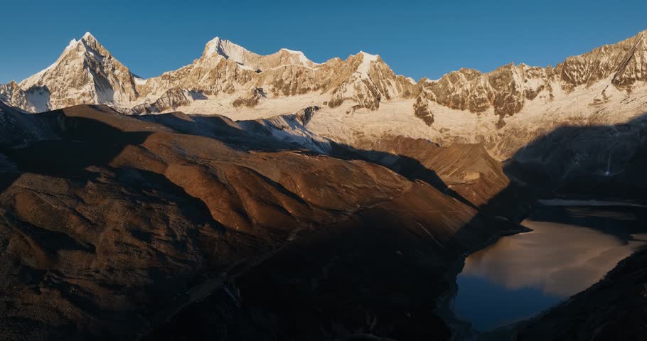 Aerial footage of beautiful snow capped mountain and lake sunrise landscape in Tibet, China
