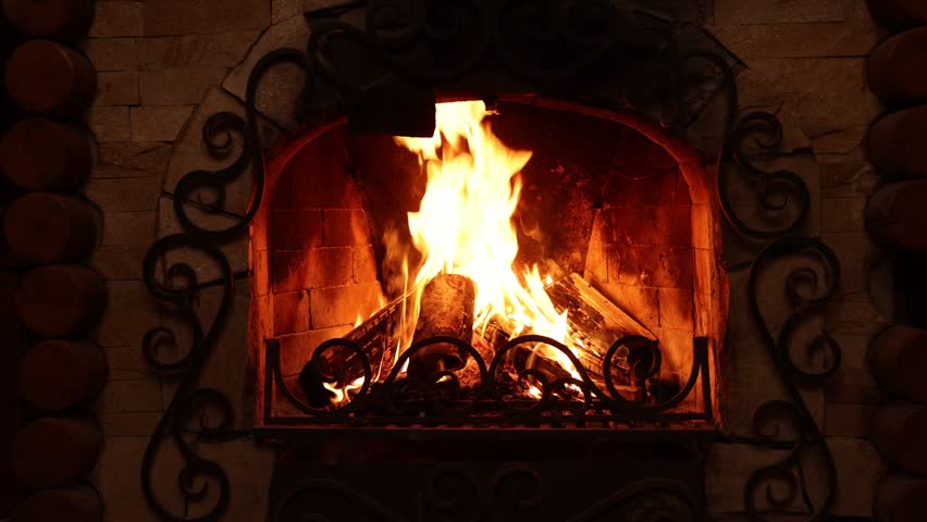 Wood burning in fireplace at home. Cozy atmosphere