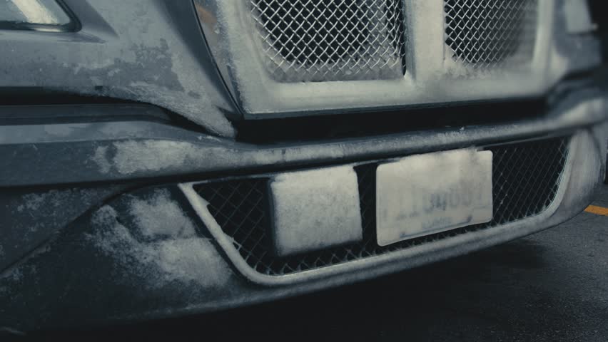 Truck bumper and grille covered in ice and snow