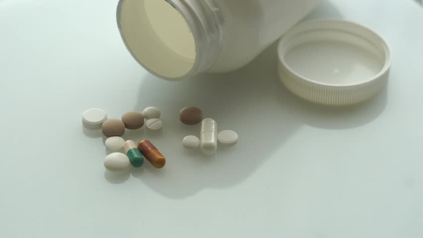 Empty container, medicines and supplements slowly spinning.