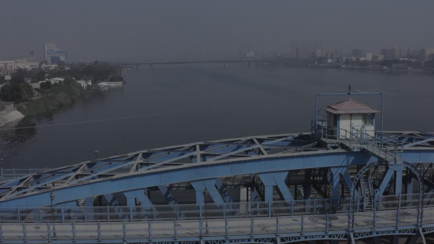 Wide aerial establishing shot of Nile River Cairo Egypt with bridges and city skyline morning haze - 4K