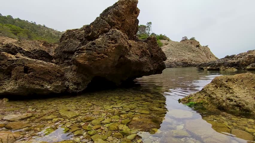 Peaceful rocky shoreline with clear water, perfect for nature enthusiasts