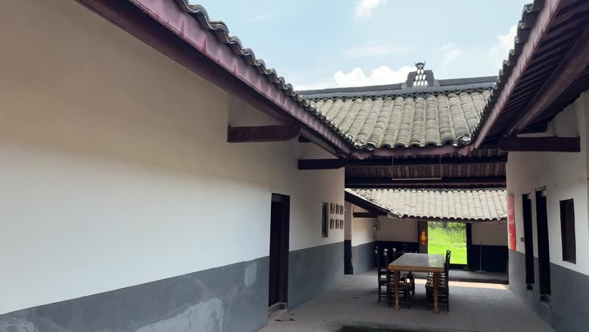 Chengdu, Sichuan China - May 13 2026: Looking through the traditional wooden courtyard of the Zhu Xi Ancestral Hall with a view of the green landscape beyond.