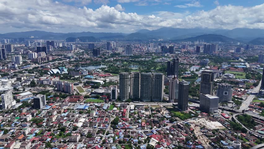 Drone view of Kuala Lumpur city skyline with high-rise buildings, residential areas and mountains in the background in Kuala Lumpur, Malaysia.