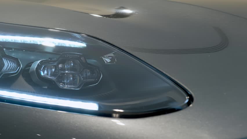 Close-up of premium sports car headlight with LED daytime running lights, showcasing modern automotive technology, luxury styling and precision engineering.