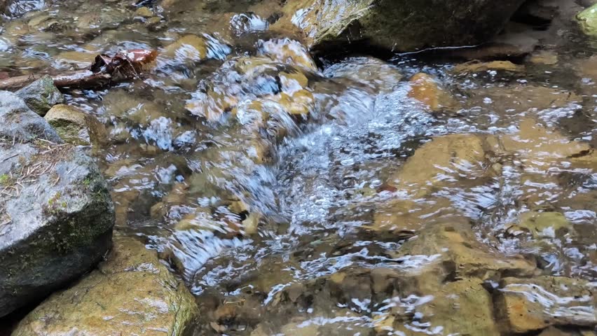 a stream running in the mountains exudes calm, coolness and peace