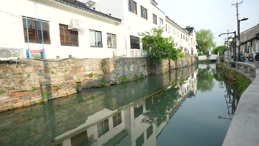 Traditional chinese architecture reflecting on the calm water of a canal in Suzhou, China