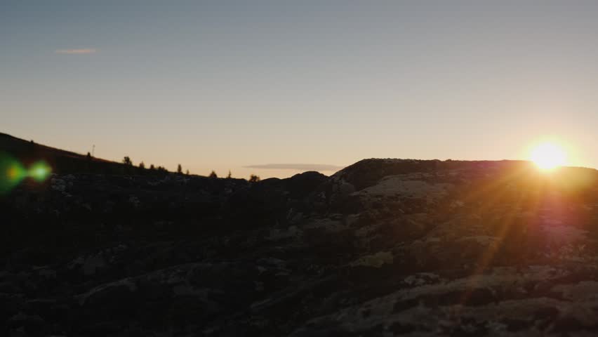 Hiking at sunset, rocky path, nature view, outdoor adventure.