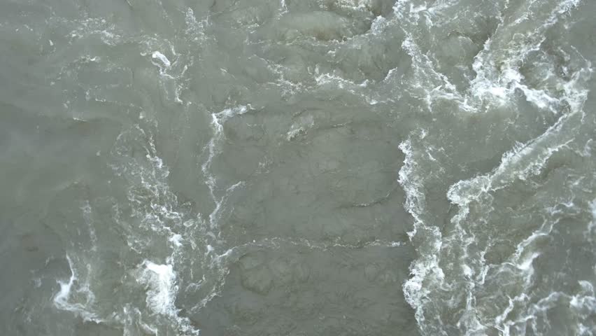 stormy stream with swirls in river, top view, slow motion
