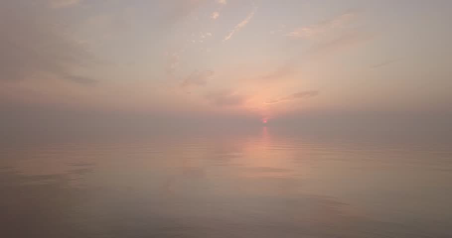 Flying a drone during an orange sunset over a calm river in summer