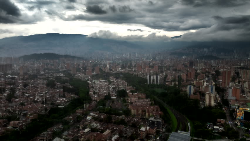 Medellin city surrounded by mountains with fast moving clouds and fog, Colombia. Hyperlapse, Aerial drone panoramic view