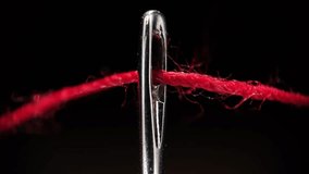 Red thread passing through eye of a needle sewing macro - Powered by Shutterstock - Get 15% off with code: PIKWIZARD15