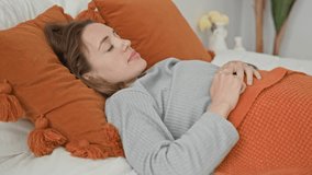 Woman stretches arms on bed over orange tassel pillow and knit blanket in a residential building; morning serenity. - Powered by Shutterstock - Get 15% off with code: PIKWIZARD15