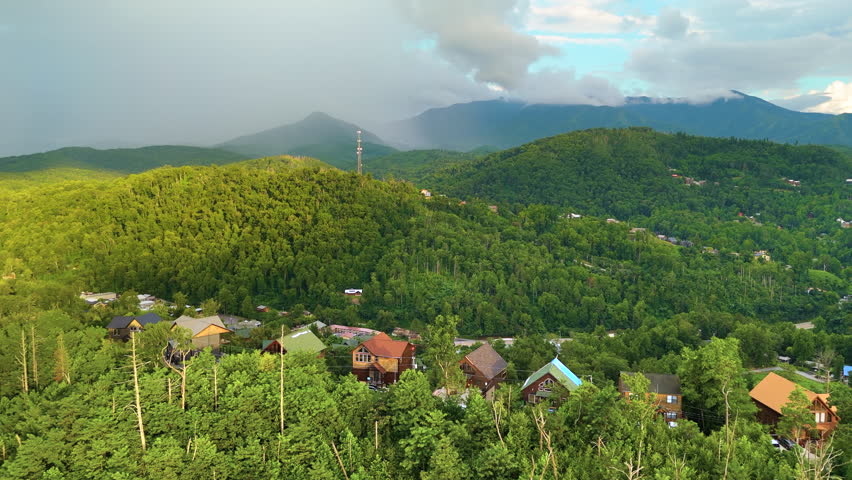 Aerial panorama of mountain residences in Tennessee surrounded by dense forest, winding roads and scenic Appalachian scenery