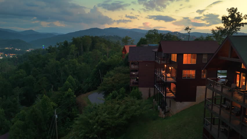Beautiful homes in Gatlinburg, Tennessee nestled in the Great Smoky Mountains with scenic forest landscape and summer colors at night.