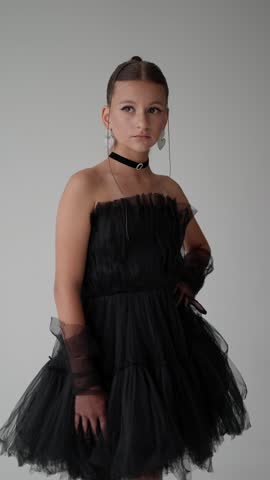 Teenage girl posing in a tulle dress with stylish jewelry. Concept of a fashionable portrait of a child.