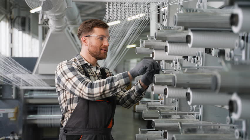Factory worker operating a textile loom machine