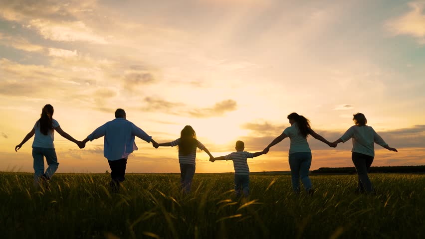 Happy family, children running green grass holding hands. Parents dad mom, children run for walk, sun park. Large group of people, adults children, enjoying nature. Family walk summer meadow. Kids sky