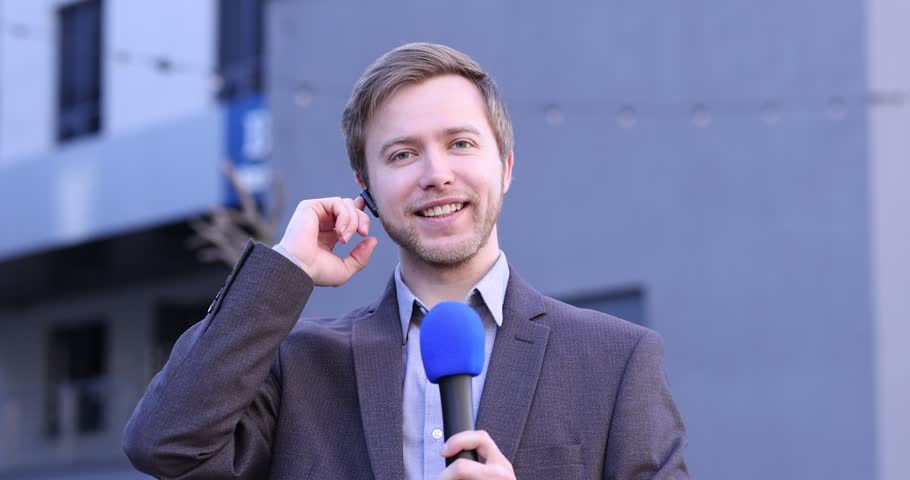 Professional journalist with microphone near building outdoors
