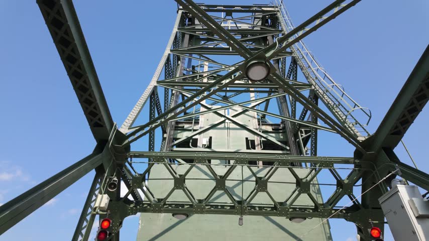 Gimbal close booming down shot of a riverboat passing through the raised lift bridge on the St. Croix River in Stillwater, Minnesota. 4K