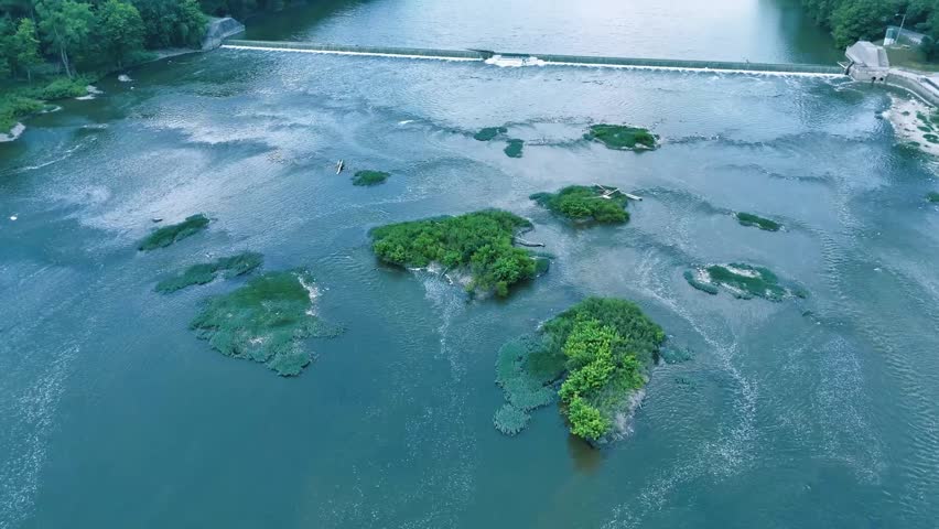Drone circling a small series of islands just past a dam.