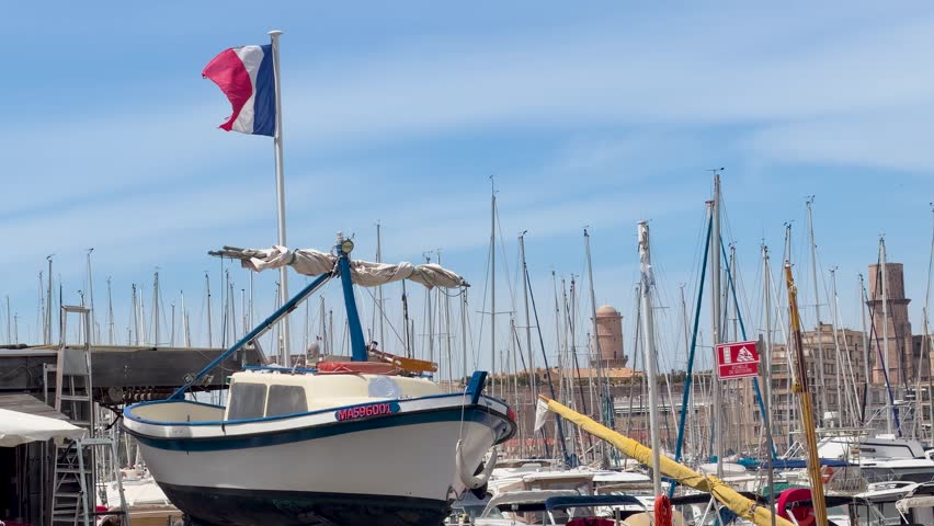 A French flag waves atop a fishing boat docked in the historic Vieux Port harbor