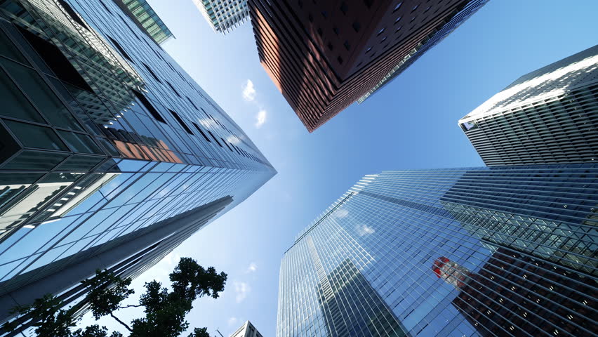 Vertical perspective of modern office buildings in Tokyo with blue sky.