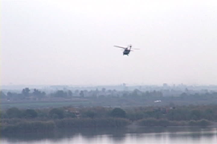Two military helicopters fly over the Tigris River in Tikrit, Iraq.