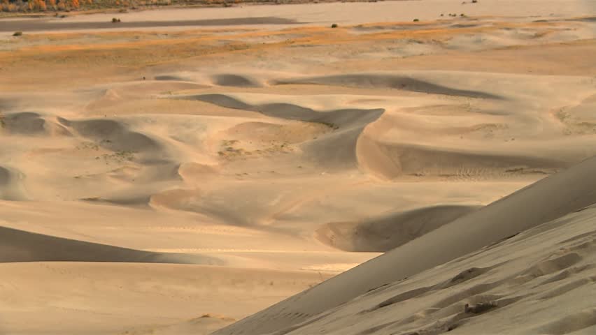 Wide view of desert sand dunes with wind shaped ridges in Great Sand Dunes National Park. Static shot