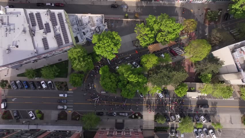 May Day Protest Marchers On City Street Near City Hall Of Tacoma In Washington, USA. aerial topdown shot