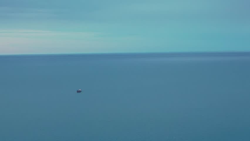 Wide aerial shot of the calm blue waters of Lake Michigan with a single small boat in the distance.