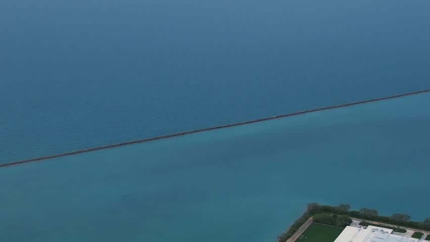 Long aerial shot of the stone breakwater protecting the Chicago harbor in Lake Michigan.