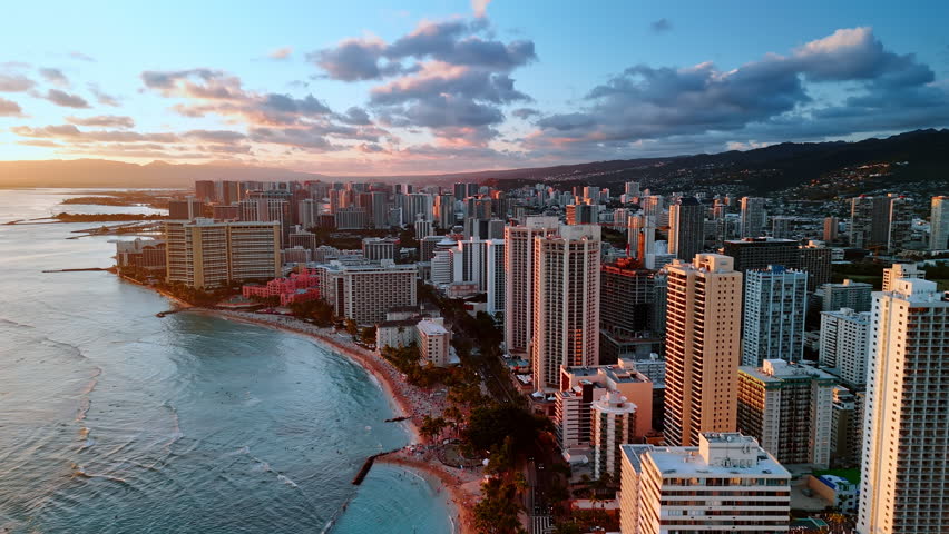 Coast of the Pacific Ocean at sunset time. Scenery of beautiful beach of Waikiki in Honolulu, Hawaii, USA. Aerial view.
