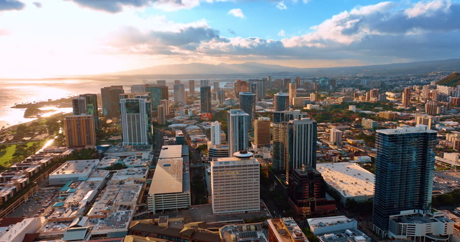 Dazzling light of setting sun covering the scenery of Honolulu, Hawaii, USA. Beautiful clouds over the panorama. Aerial view.