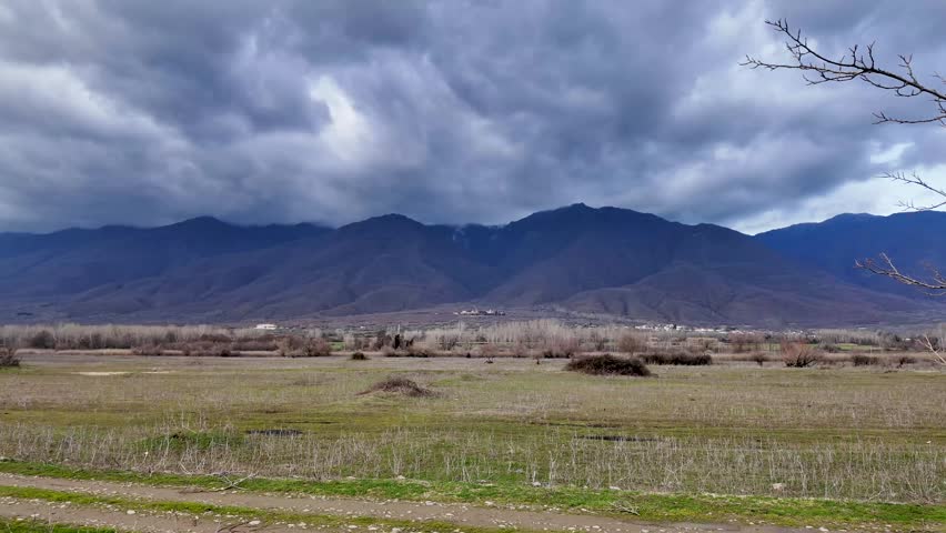 landscape with mountains in the background, cloudy weather