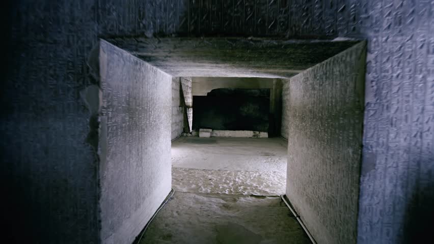 Bare limestone interior burial chamber inside pyramid of Teti at Saqqara necropolis, Egypt, narrow corbelled ceiling passage leading to dark empty sarcophagus room.