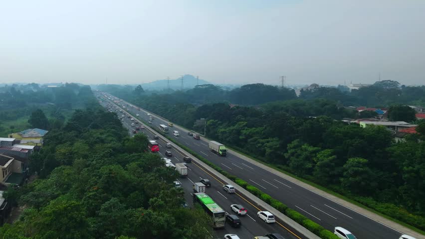 Wide-angle perspective of an urban toll road with a clear view of the distant horizon and hazy sky.