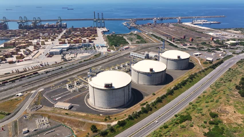 View of lng terminal with gas storage tanks and energy infrastructure. Located near port facilities, the site supports natural gas supply and storage for regional energy needs.