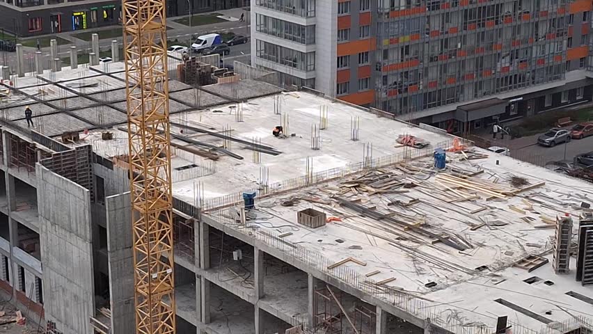Concrete building under construction with scaffolding and unfinished floors, urban development site, industry growth, construction progress, modern architecture.