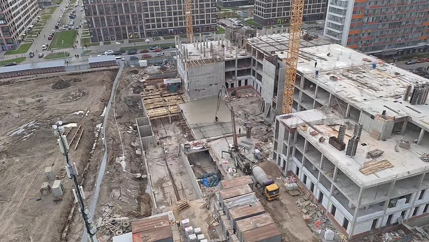 Urban building under construction with scaffolding, cranes, and materials, progress of new architecture, industrial zone, city growth, engineering project underway.