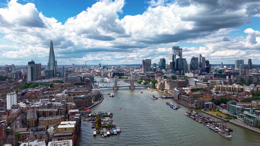 Aerial view of the cityscape of London, England, with City, Tower Bridge and River Thames during a sunny summer day with cloudscape