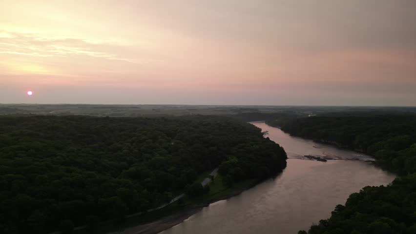 Seeing the sun on a haze day sunrise over a natural tree parkland in Linn County, Iowa. Palisades State Park.  4k, drone, flying