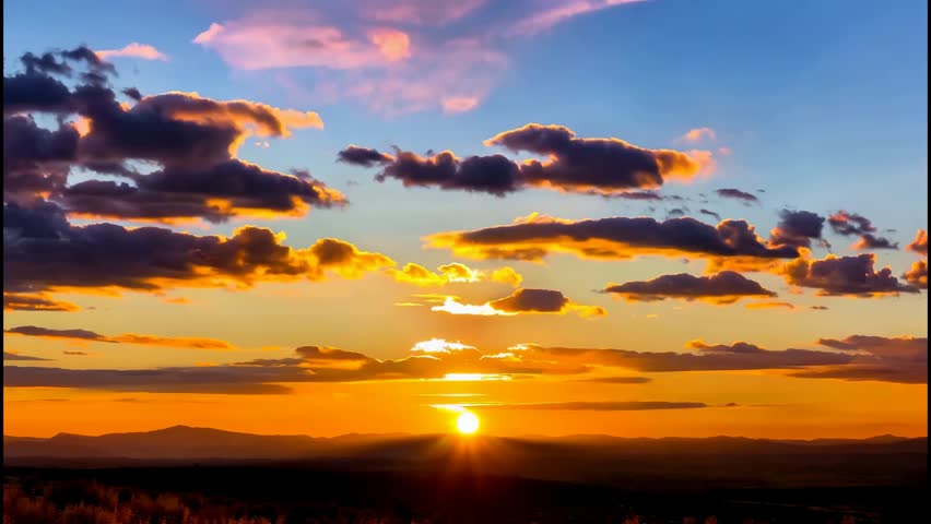Golden Sunset Over Mountain Horizon With Dramatic Cloudy Sky