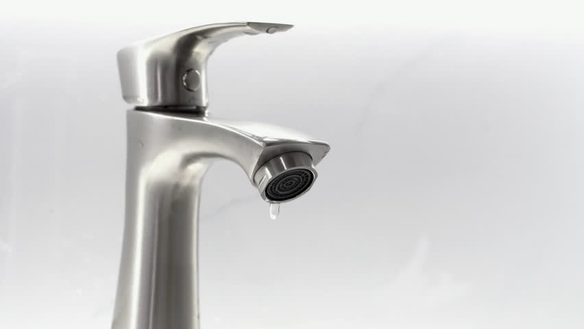 Closeup of water dripping from faucet tap at bathroom.
