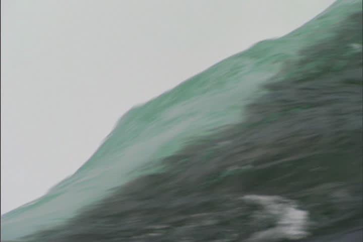 Abstract view of rushing water, camera pulls back to show water cascading over edges of Horseshoe Falls at Niagara Falls, Ontario, Canada.