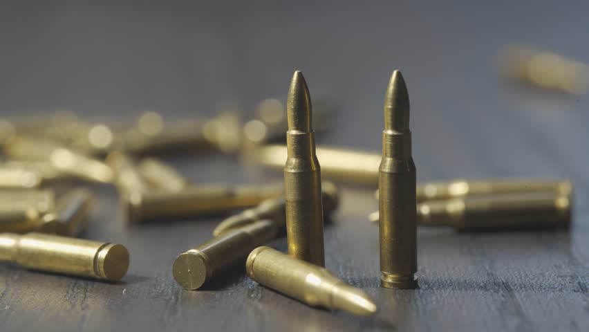 Many bullets on a wooden table. Concept of military, weapons and ammunition.