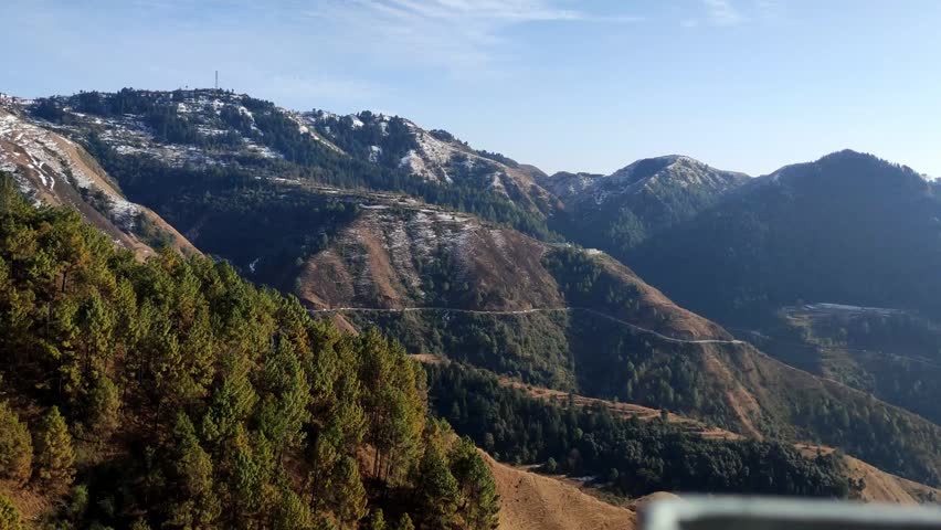 Breathtaking aerial view of a winding mountain road on a sunny daylight