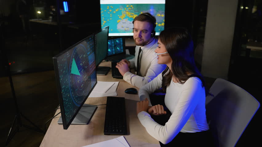 Air traffic controllers collaborating in a dark control tower