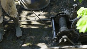 Heavy duty industrial winch machine with steel cable drum operating at a construction site next to a worker. - Powered by Shutterstock - Get 15% off with code: PIKWIZARD15