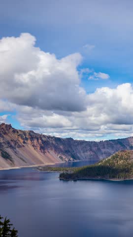 Time lapse of puffy clouds moving across the sky above Crater Lake in Oregon. Vertical video.